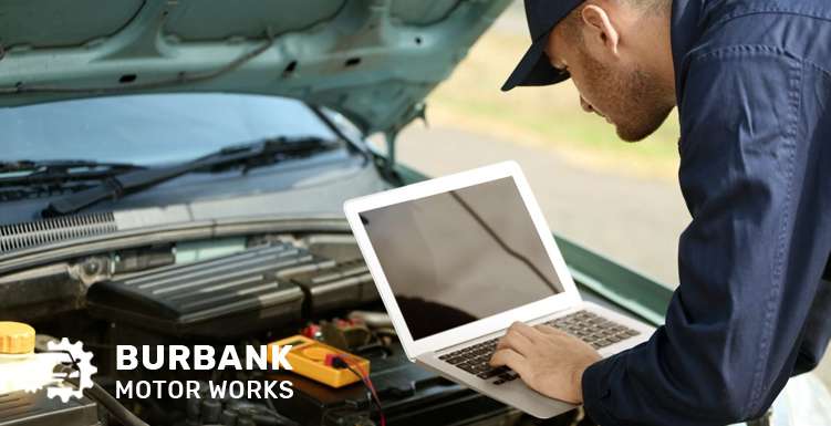 Mechanic inspecting or replacing an O2 sensor in the car engine bay