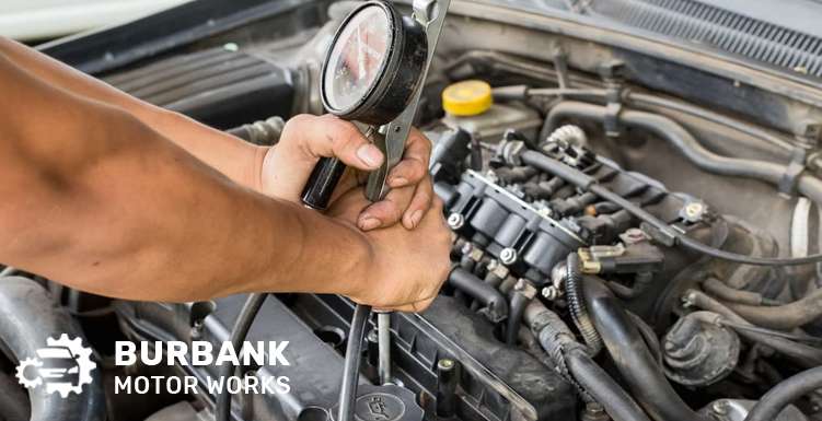 Mechanic removing a damaged cylinder head from an engine.