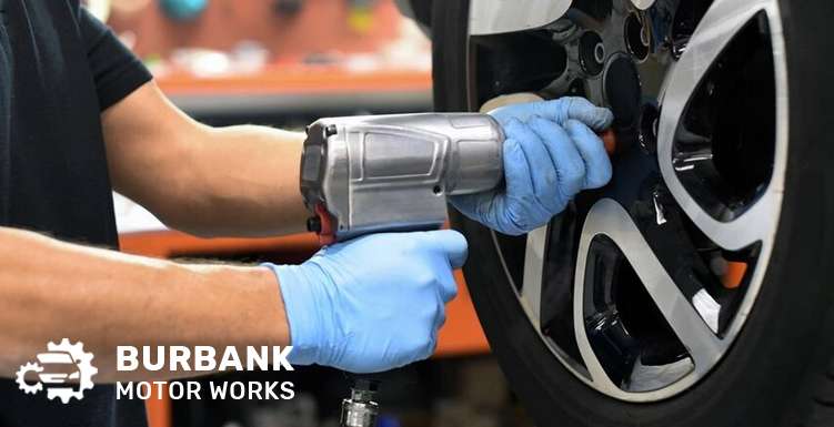 Mechanic performing a wheel alignment on a car.